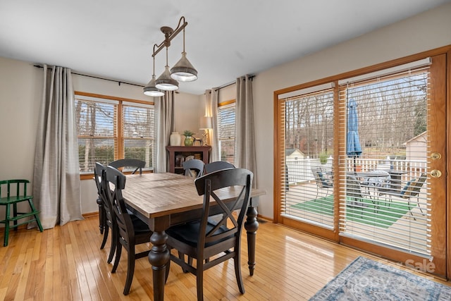 dining space with light wood finished floors and baseboards