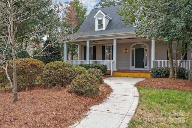 view of front of property with covered porch, ceiling fan, and a shingled roof