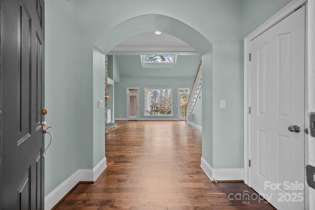 foyer entrance with dark wood finished floors, stairway, and baseboards