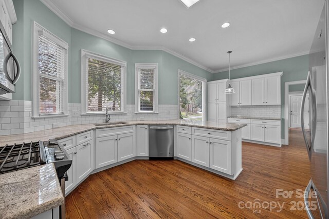 kitchen with light stone counters, dark wood-style floors, a sink, white cabinets, and appliances with stainless steel finishes