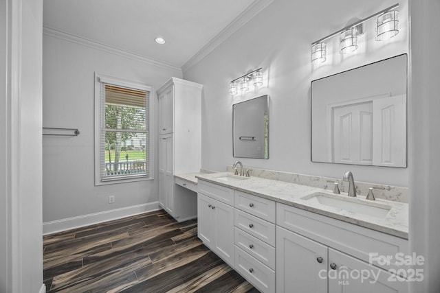 bathroom with ornamental molding, wood finished floors, baseboards, and a sink