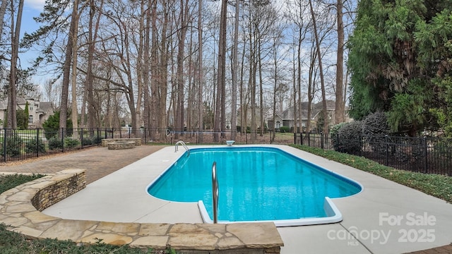 view of swimming pool featuring a patio area, a fenced backyard, a fenced in pool, and an outdoor fire pit