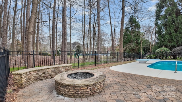 view of pool featuring a fenced in pool, fence, an outdoor fire pit, a patio area, and a diving board