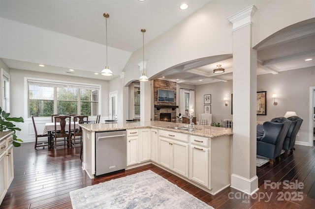 kitchen featuring light stone counters, arched walkways, dark wood-type flooring, open floor plan, and a sink