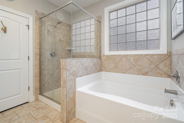 bathroom featuring a stall shower and a bath