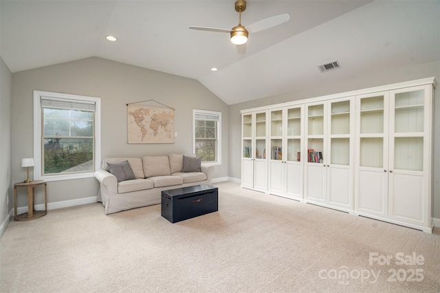 living area with lofted ceiling, carpet floors, visible vents, and baseboards