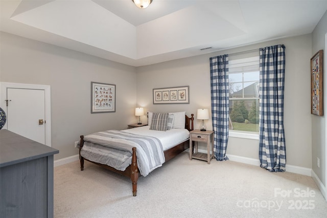 bedroom featuring baseboards, visible vents, a tray ceiling, and light colored carpet