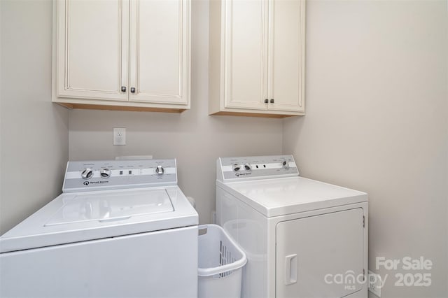 clothes washing area featuring washing machine and clothes dryer and cabinet space