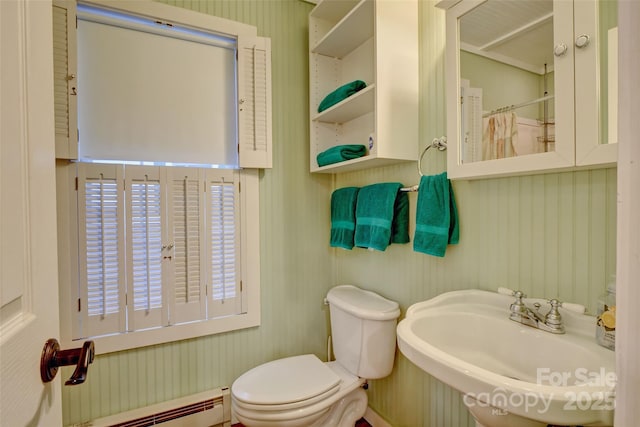 bathroom with sink, baseboard heating, and toilet