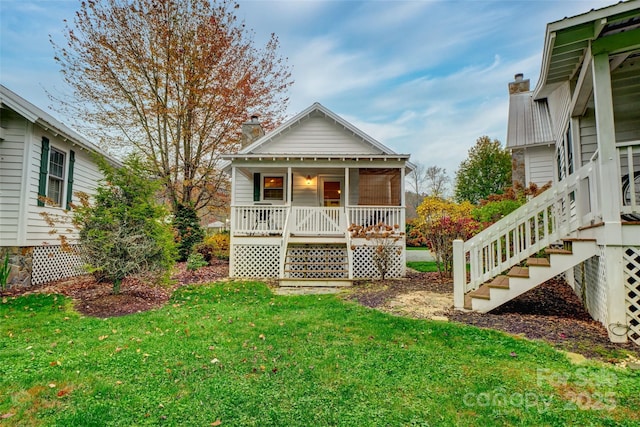 rear view of property with a yard and a porch