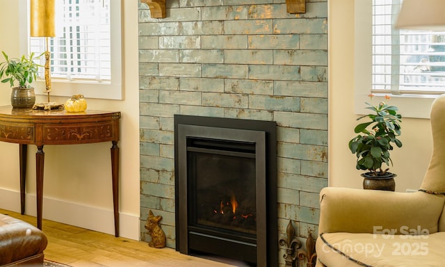 living area featuring a wealth of natural light, a fireplace, and hardwood / wood-style flooring