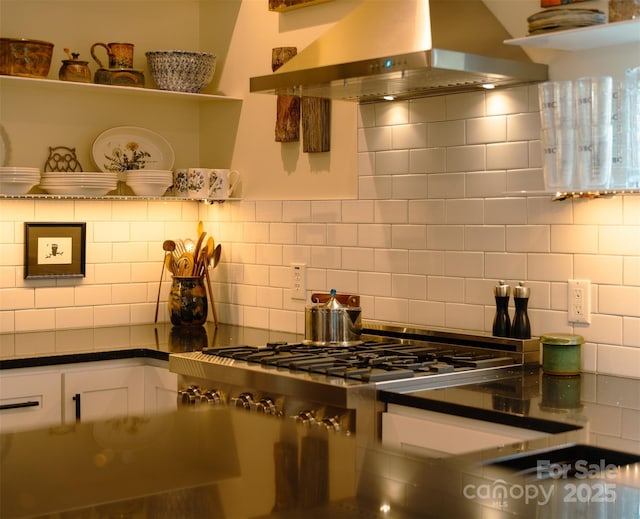 kitchen featuring white cabinetry, backsplash, island range hood, and stainless steel gas cooktop