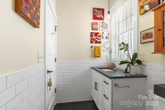 bathroom with tile walls, vanity, and toilet