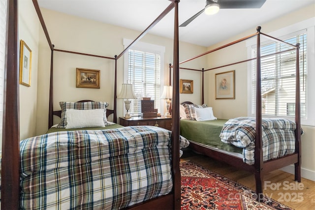 bedroom with hardwood / wood-style flooring, ceiling fan, and multiple windows