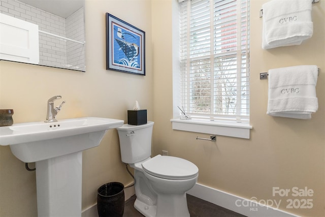 bathroom with sink, plenty of natural light, and toilet