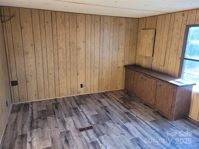 empty room featuring dark wood-type flooring and wood walls