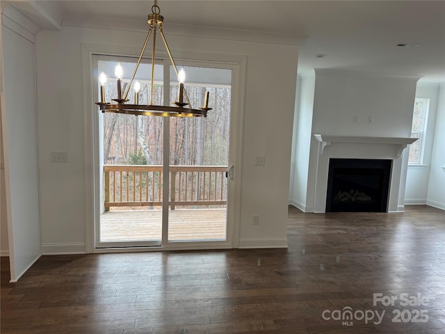 unfurnished dining area featuring crown molding, dark hardwood / wood-style floors, and an inviting chandelier