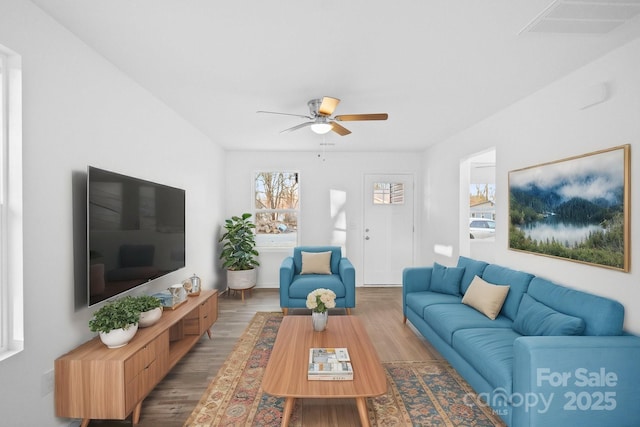 living room with wood-type flooring and ceiling fan