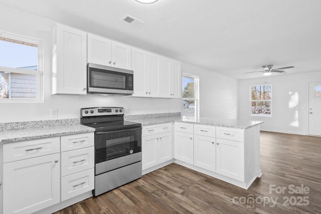 kitchen featuring white cabinetry, dark wood-type flooring, kitchen peninsula, and appliances with stainless steel finishes