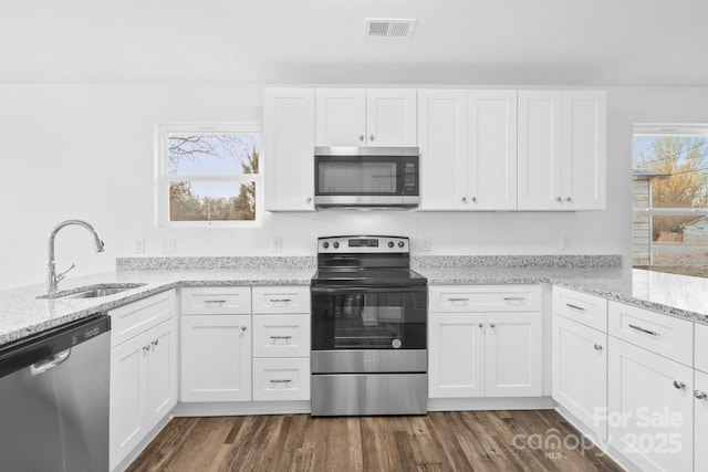 kitchen featuring light stone counters, stainless steel appliances, sink, and white cabinets