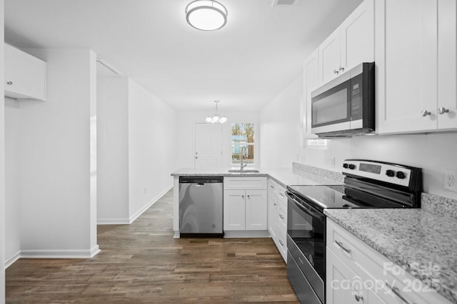 kitchen featuring sink, stainless steel appliances, white cabinets, dark hardwood / wood-style flooring, and decorative light fixtures