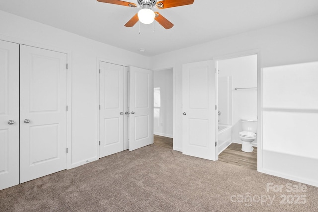 unfurnished bedroom featuring multiple closets, connected bathroom, and light carpet