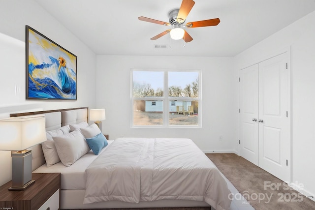 carpeted bedroom featuring ceiling fan and a closet