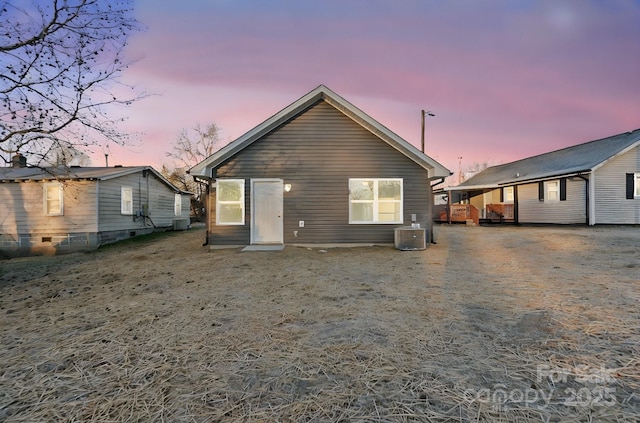 back house at dusk featuring central AC unit