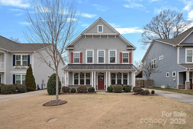 view of property featuring covered porch and a front lawn