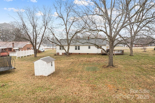 view of yard with a deck, a trampoline, and a shed