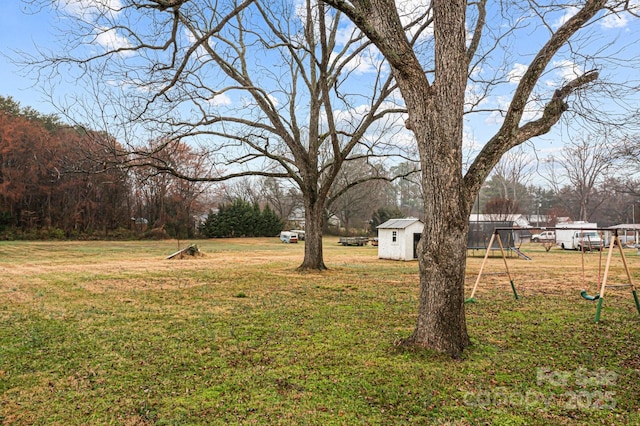 view of yard featuring a storage unit and a playground