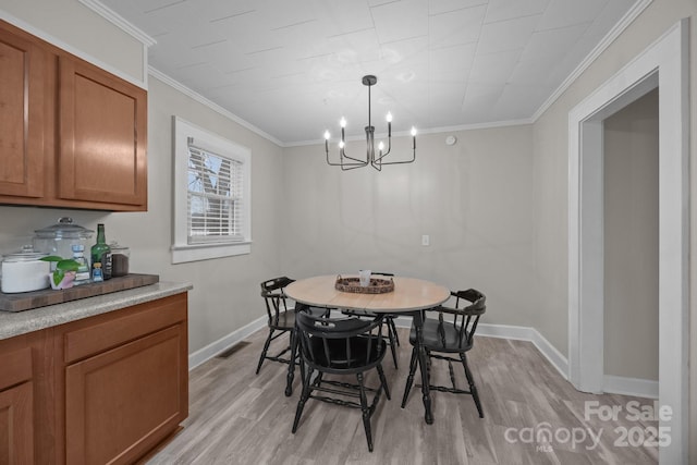 dining room featuring ornamental molding, a chandelier, and light hardwood / wood-style floors