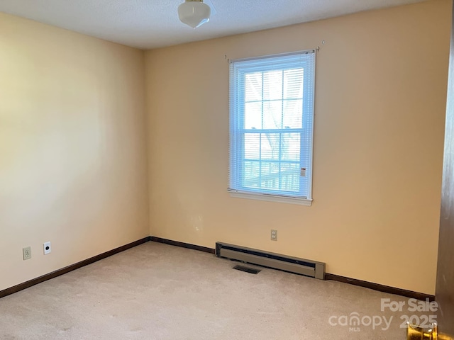 carpeted empty room with baseboard heating