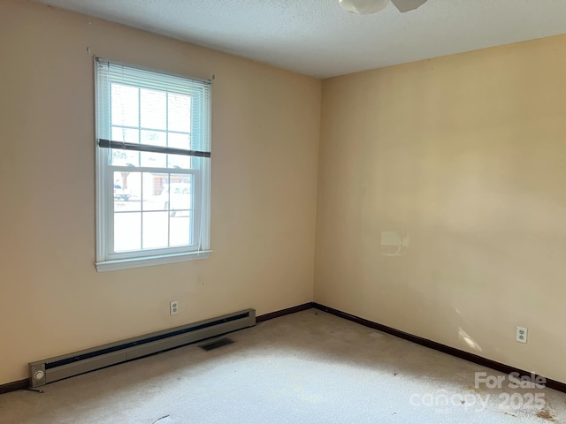 carpeted spare room featuring a textured ceiling, a baseboard radiator, and a healthy amount of sunlight