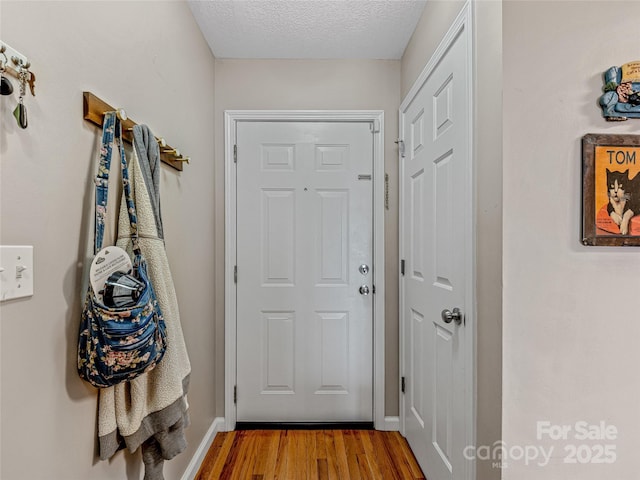 doorway featuring hardwood / wood-style floors and a textured ceiling