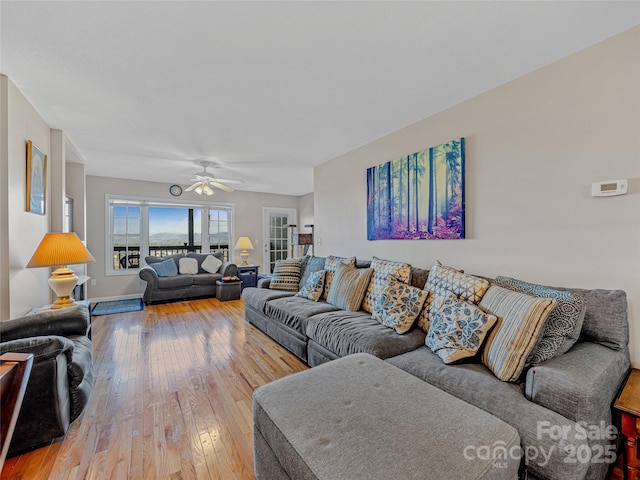 living room with wood-type flooring and ceiling fan
