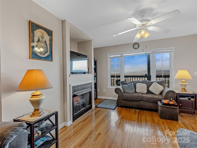 living room featuring ceiling fan and light wood-type flooring