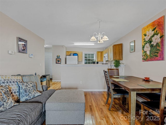 dining area with a notable chandelier and light hardwood / wood-style flooring