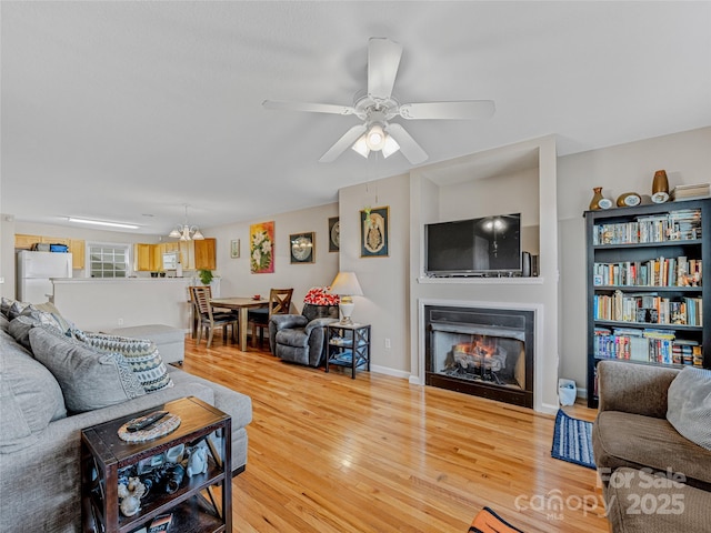 living room featuring hardwood / wood-style flooring and ceiling fan with notable chandelier