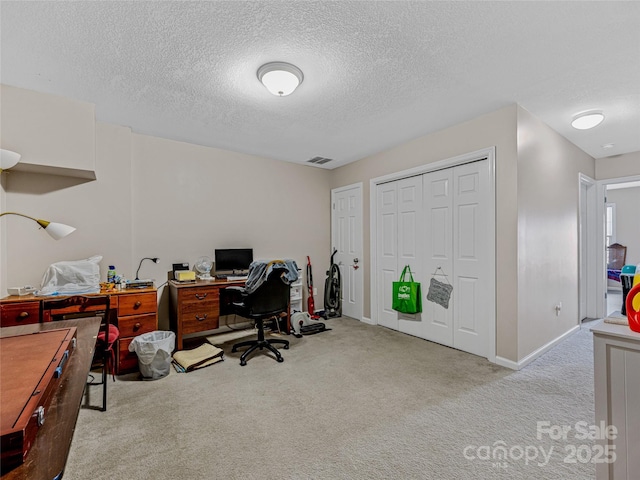 carpeted office with a textured ceiling