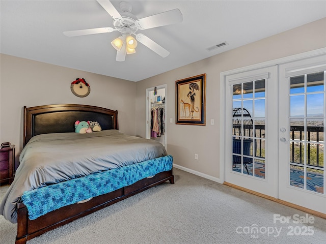 carpeted bedroom with french doors, ceiling fan, a walk in closet, and access to outside