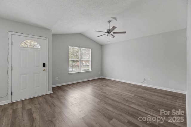 entrance foyer with dark wood-type flooring, ceiling fan, vaulted ceiling, and a textured ceiling