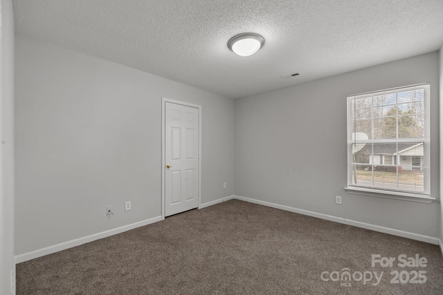 empty room featuring carpet flooring and a textured ceiling