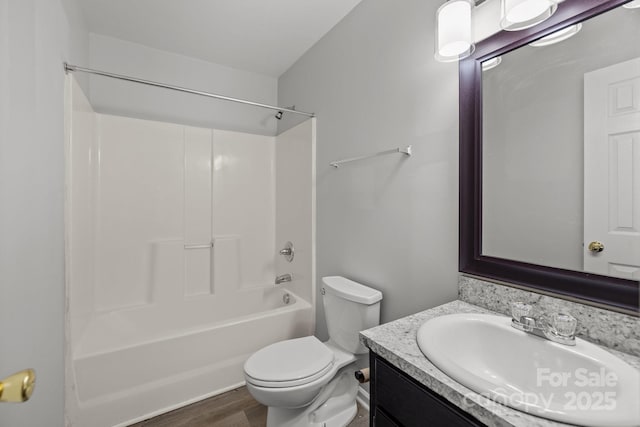 full bathroom with  shower combination, toilet, wood-type flooring, and vanity