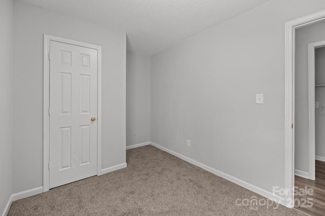 interior space featuring carpet flooring and a textured ceiling