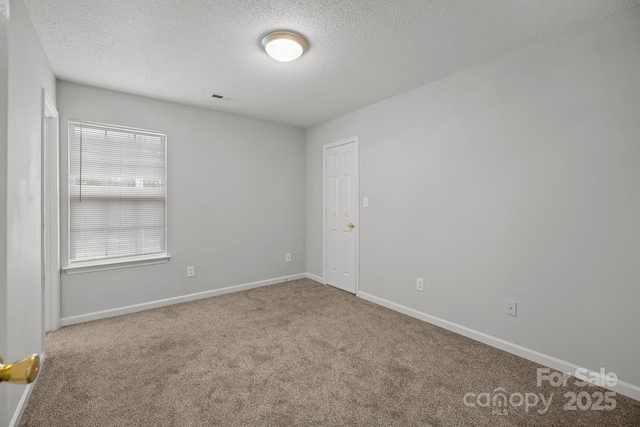 carpeted spare room with a textured ceiling