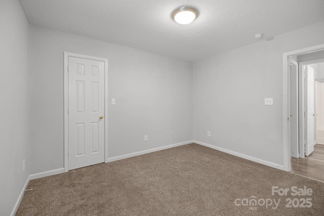 carpeted spare room with a textured ceiling