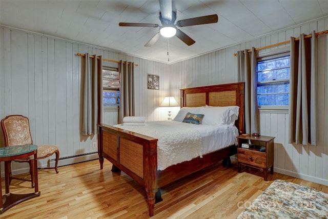 bedroom featuring ceiling fan, a baseboard radiator, and light hardwood / wood-style floors