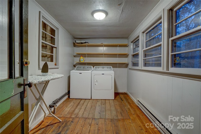 laundry room featuring separate washer and dryer, light wood-type flooring, a textured ceiling, and baseboard heating