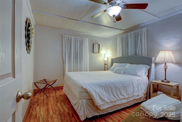 bedroom featuring crown molding, hardwood / wood-style floors, ceiling fan, and wood ceiling